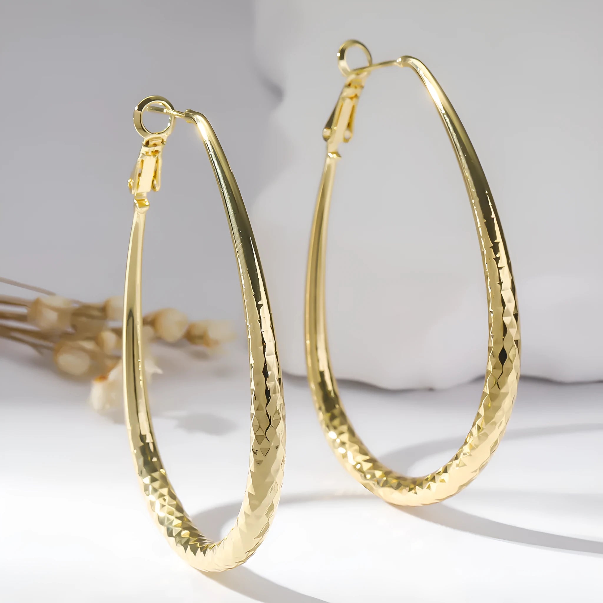 Gold glossy egg-shaped spring fastener earrings made from hypoallergenic copper, unisex geometric design