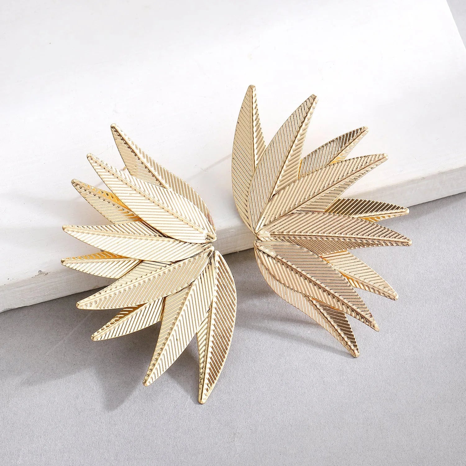 Alloy metal leaf silhouette earrings in white and gold colour options showing botanical jewellery design