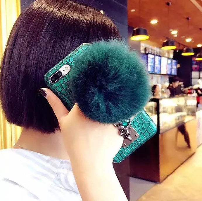 Red iPhone case with fox fur ball decoration and rhinestone studded design