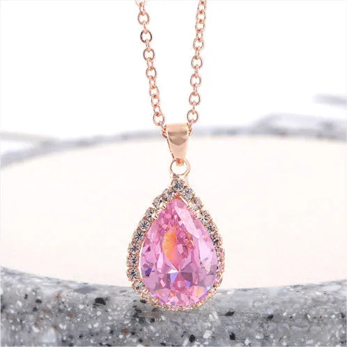 Rose gold water drop shaped necklace with geometric design and rhinestone accents in pink colour