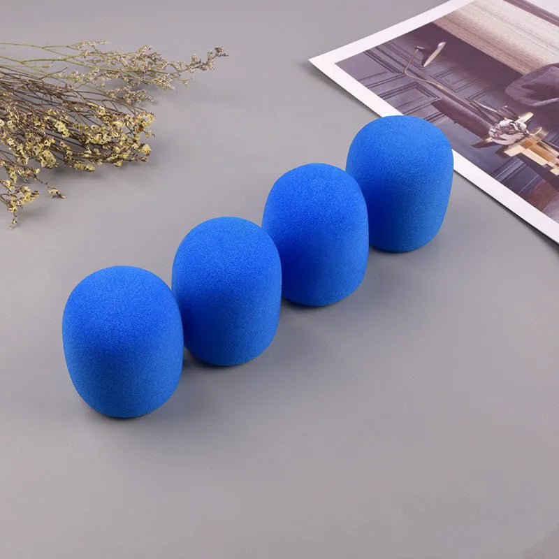 Four multicolored foam microphone windshields for handheld stage microphones on a grey background.
