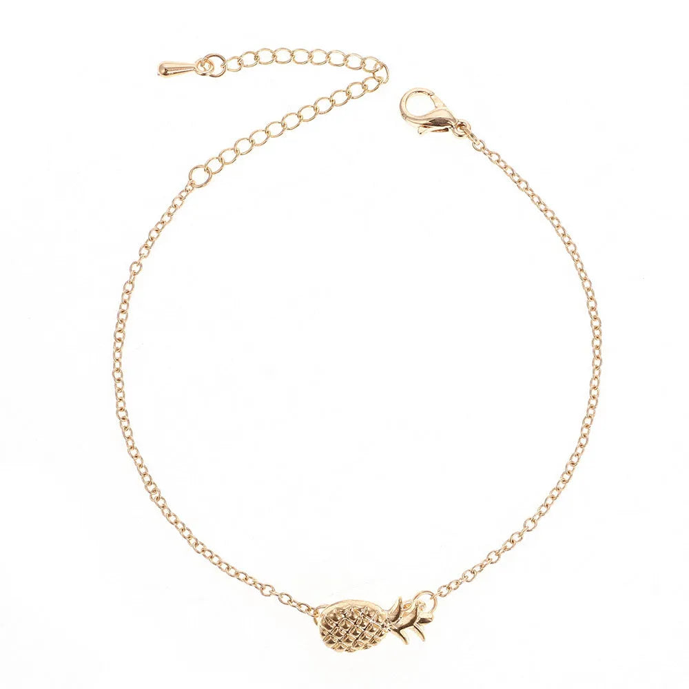 Close-up of a women's alloy bracelet with a detailed pineapple charm in gold or silver colour.