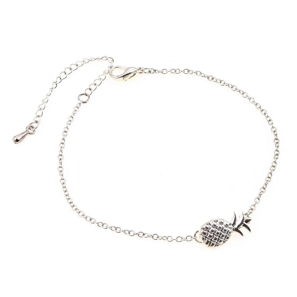 Close-up of a women's alloy bracelet with a detailed pineapple charm in gold or silver colour.