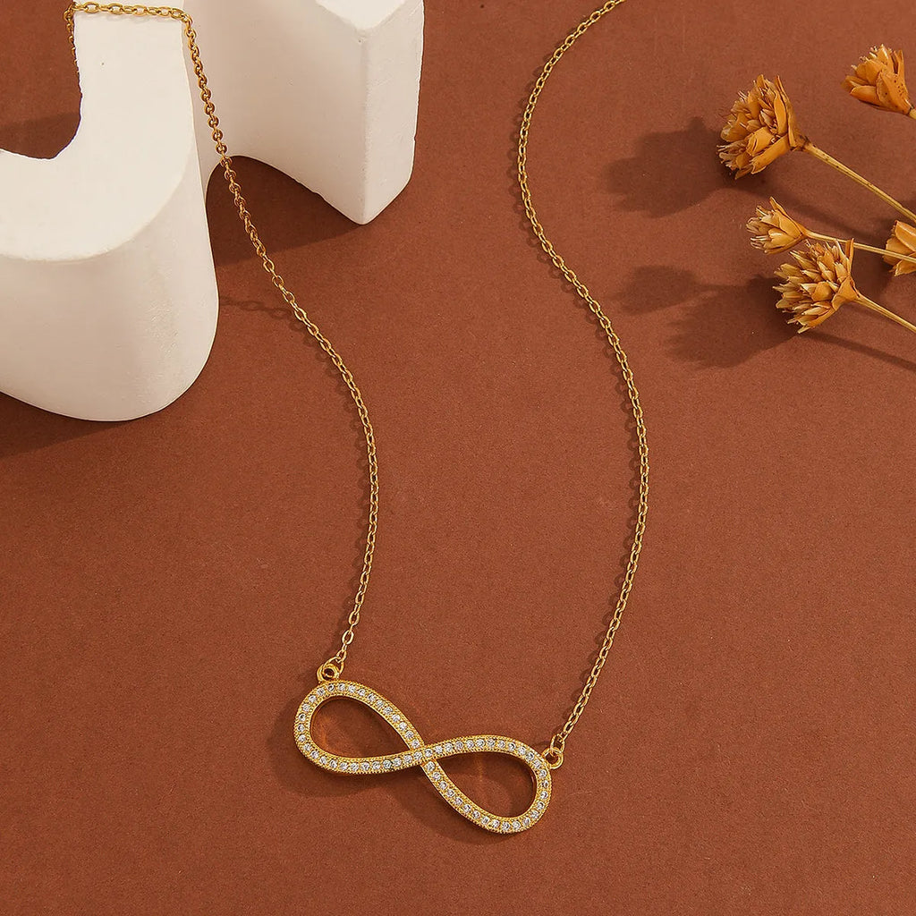 Gold plated copper infinity love pendant necklace with diamond accents and fine chain.