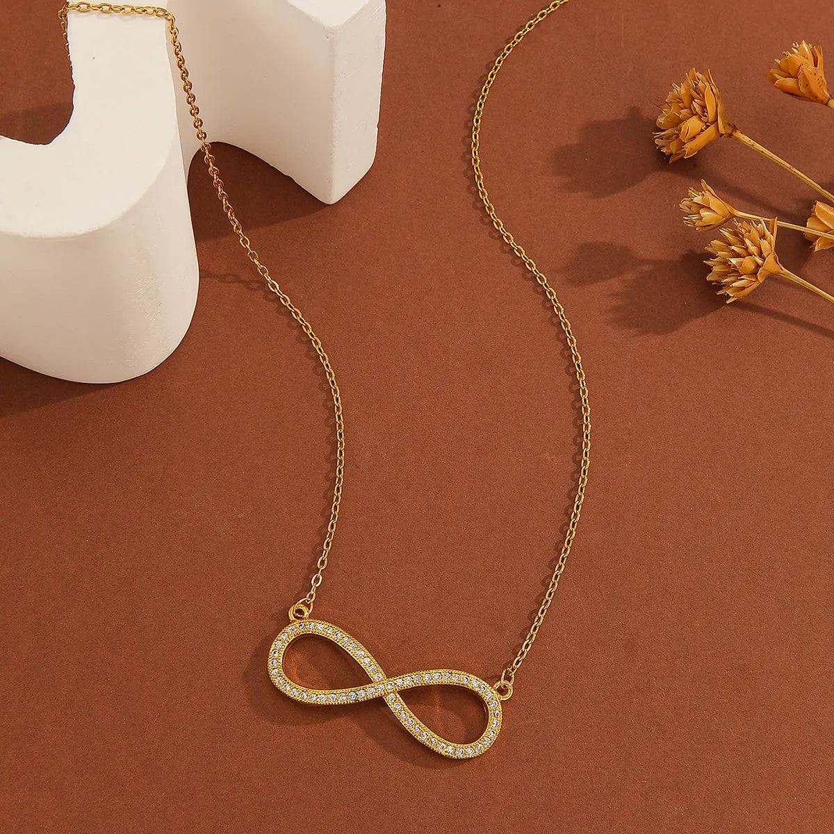 Gold plated copper infinity love pendant necklace with diamond accents and fine chain.