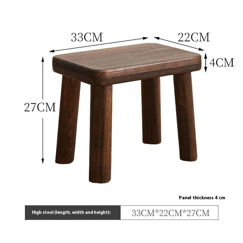 Solid wood shoe changing stool with a distressed finish and angular bracket frame.