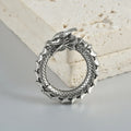 Pair of large antique silver dragon-shaped hollow-out earrings with geometric design on a plain background.
