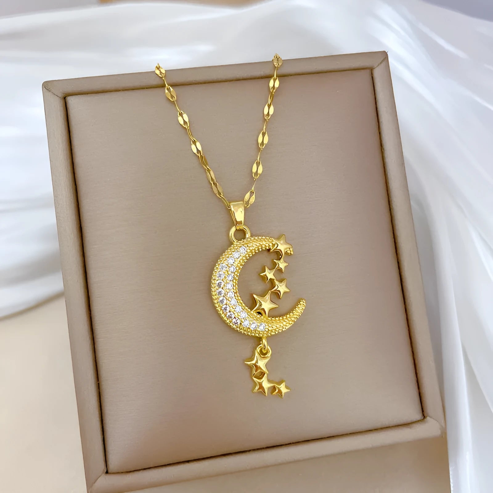 Geometric moon pendant necklace with tassel on a stainless steel chain, showing copper metal tone.