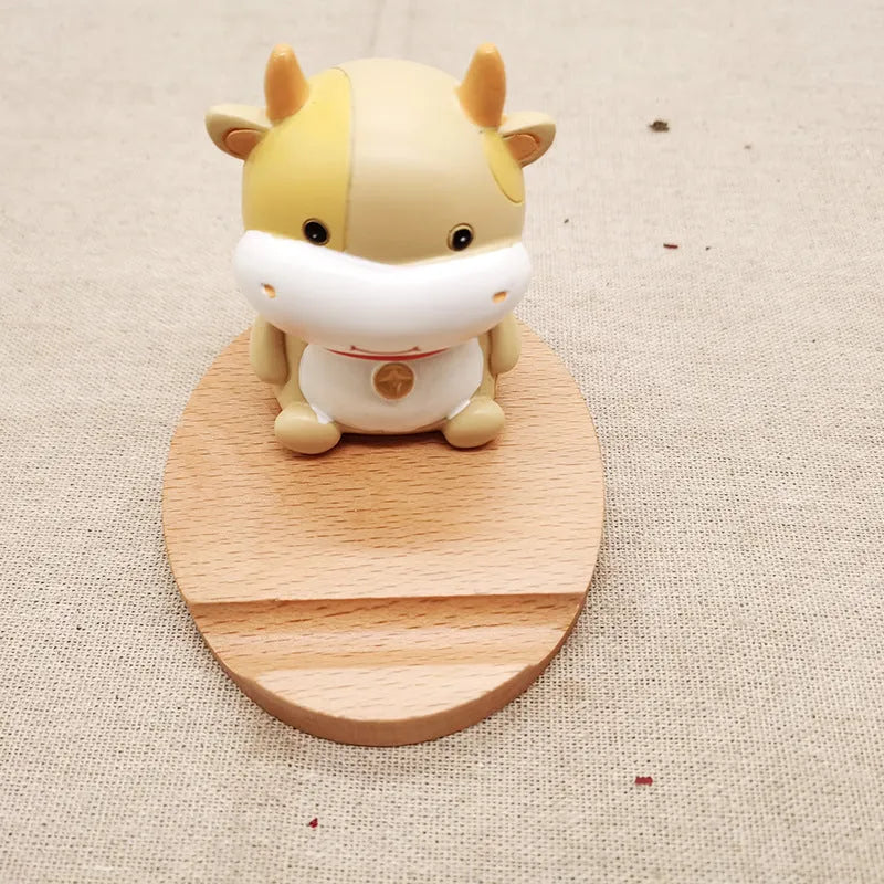 A decorative resin mobile phone stand holding a smartphone, shown in an animal design variant.