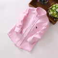 Boy's blue long sleeve cotton shirt with a lapel collar on a hanger.