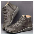 Women's black casual wedge-heel booties with round toe on a wooden floor.