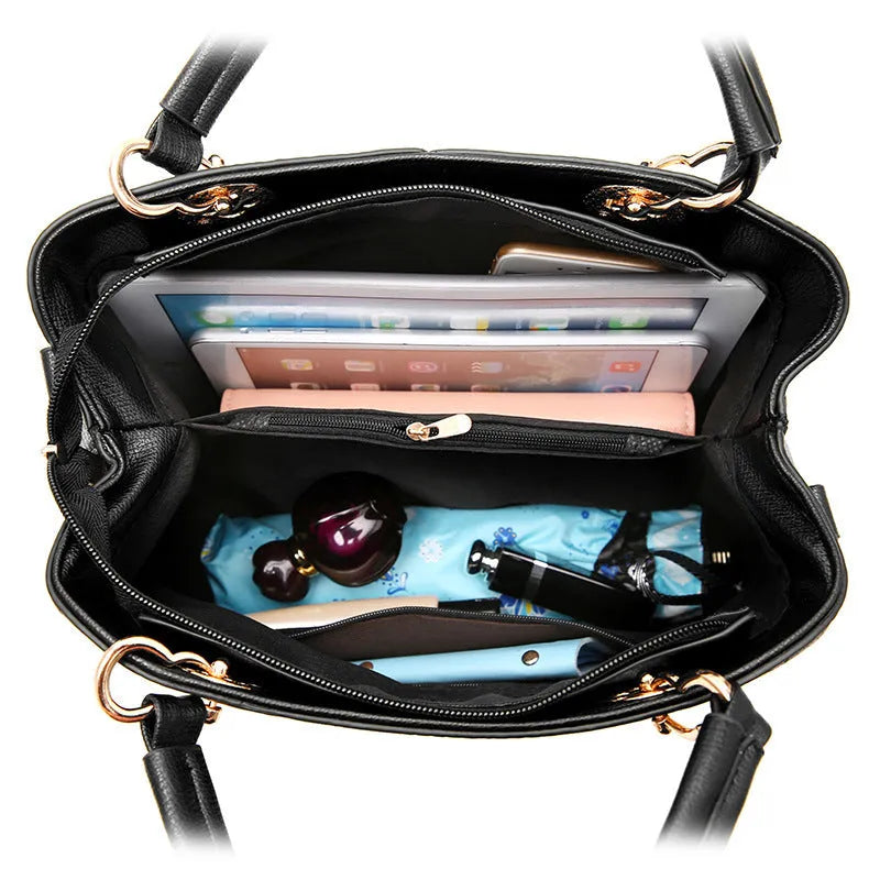 Retro-style handbag in black with a zip top and a single shoulder strap, shown with a phone and wallet inside.