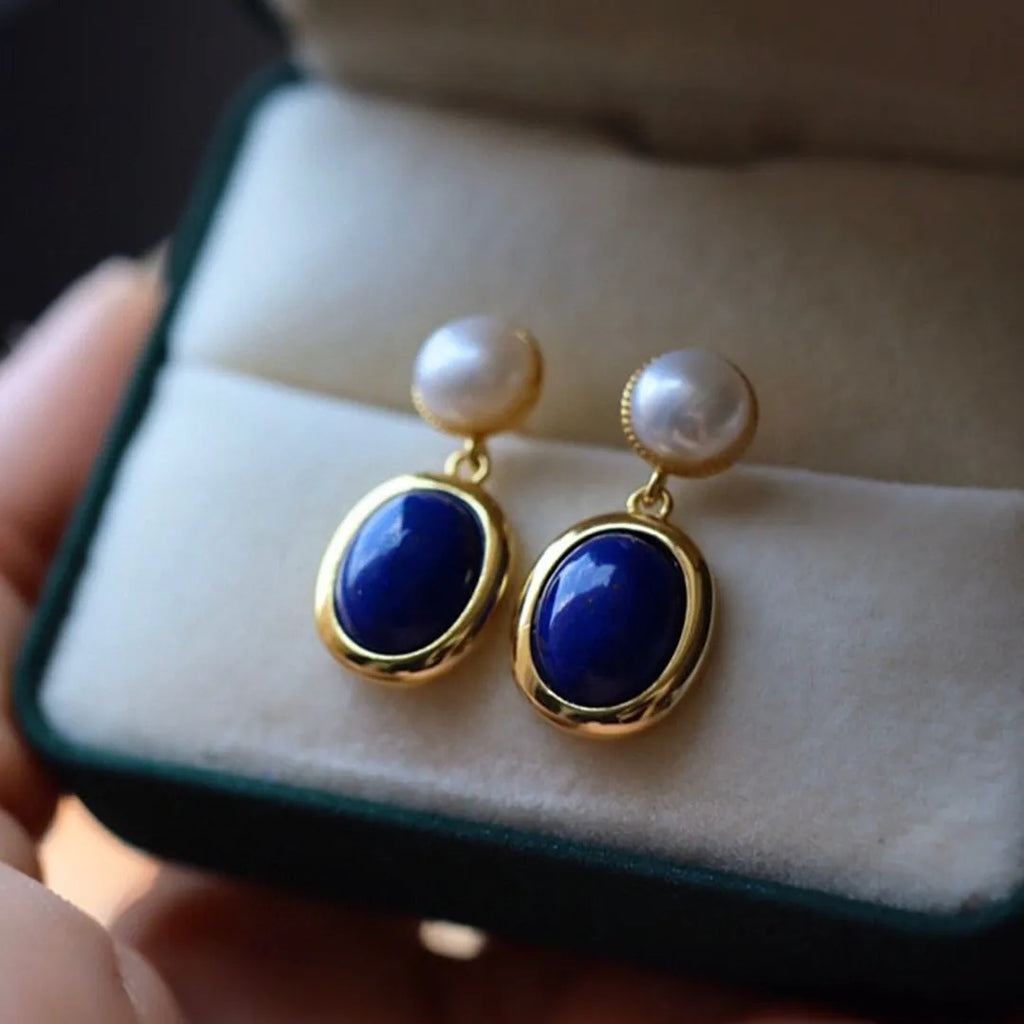 A pair of simple sterling silver earrings with a blue lapis lazuli pearl and auspicious patterns.