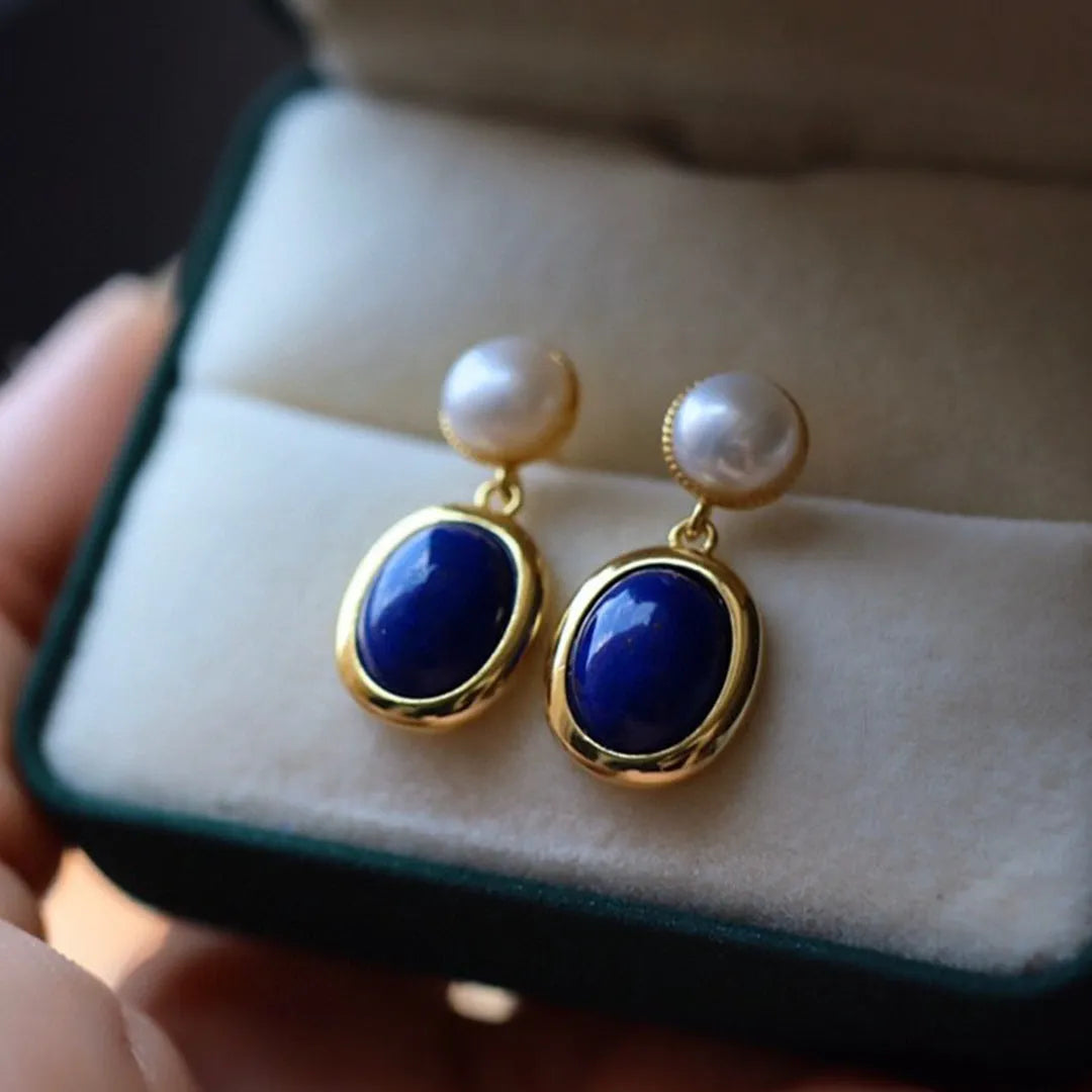 A pair of simple sterling silver earrings with a blue lapis lazuli pearl and auspicious patterns.