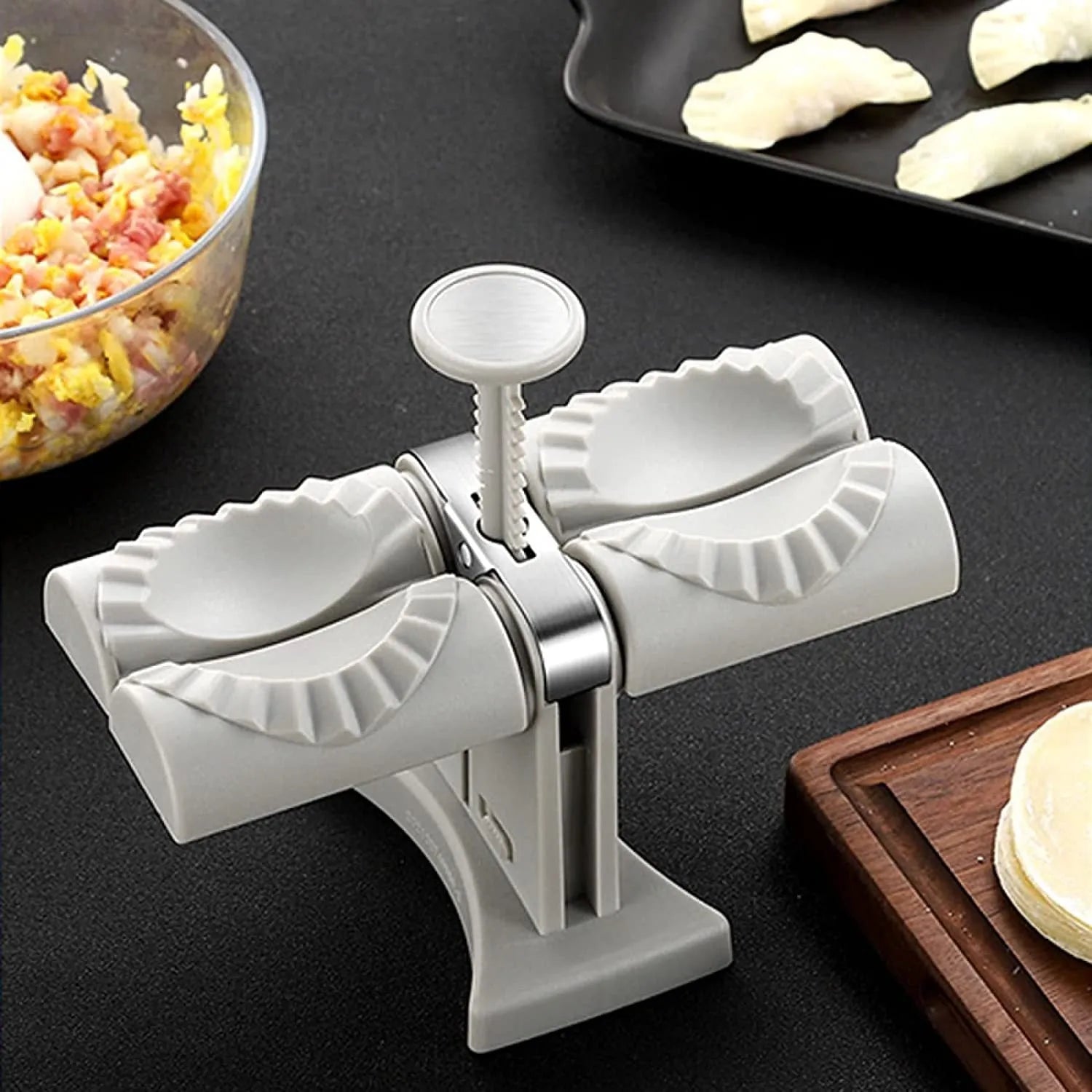White plastic manual dumpling maker with double head press and anti-slip rubber base mat.