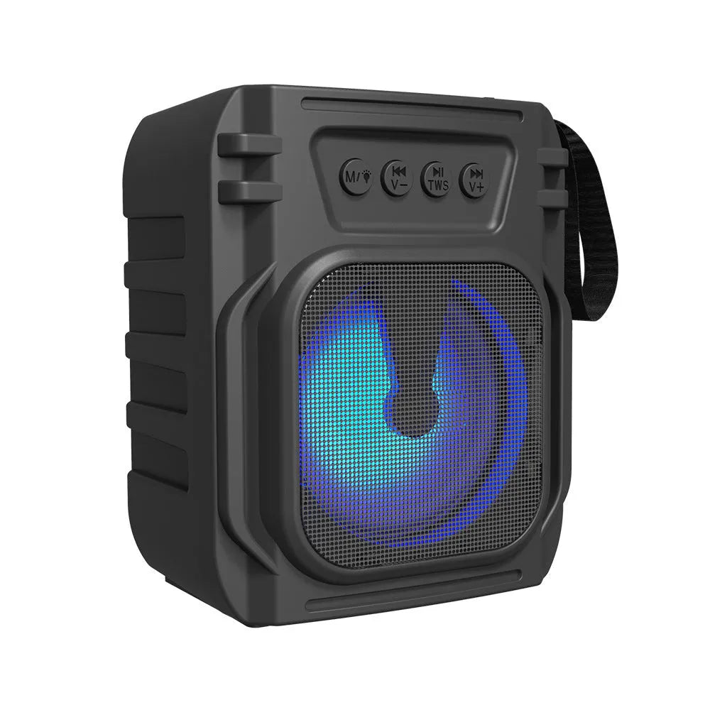 Compact portable Bluetooth speaker with USB charging cable on a table.
