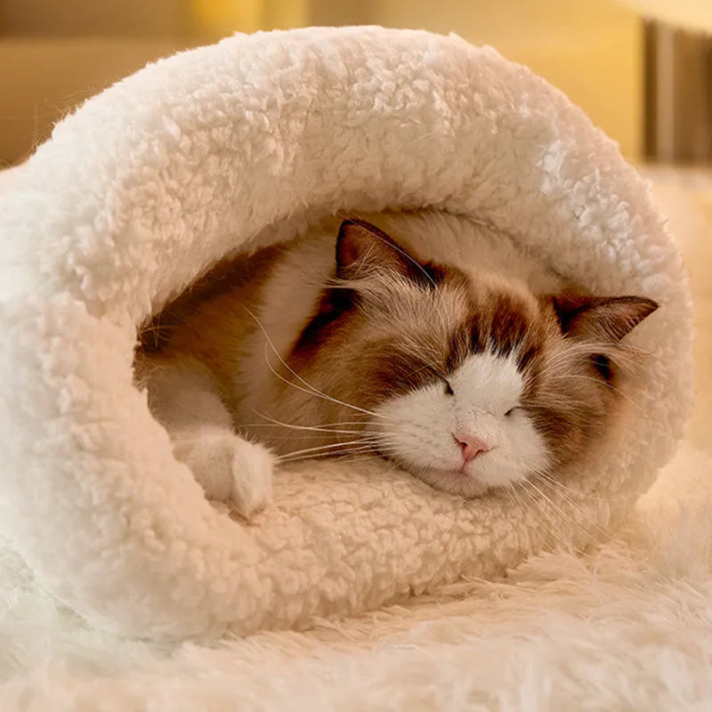Fleece cat sleeping bag nest in light brown colour with a 3D entrance, shown on a wooden floor.