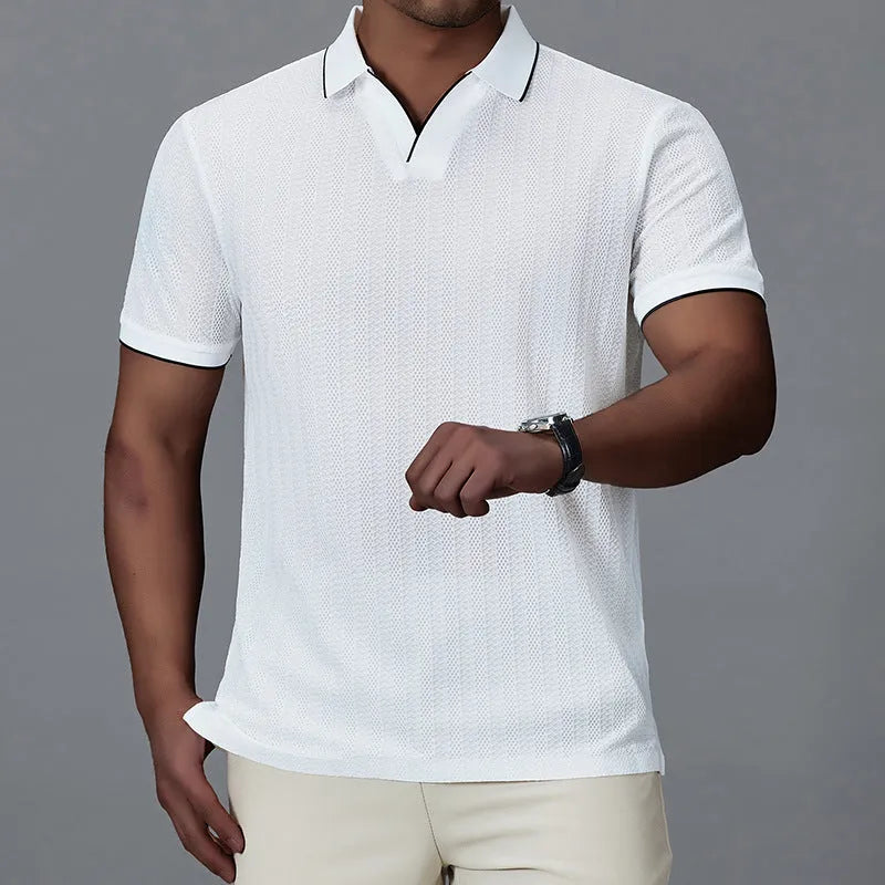 Man wearing a black loose-fit short-sleeved nylon polo shirt on a casual background.
