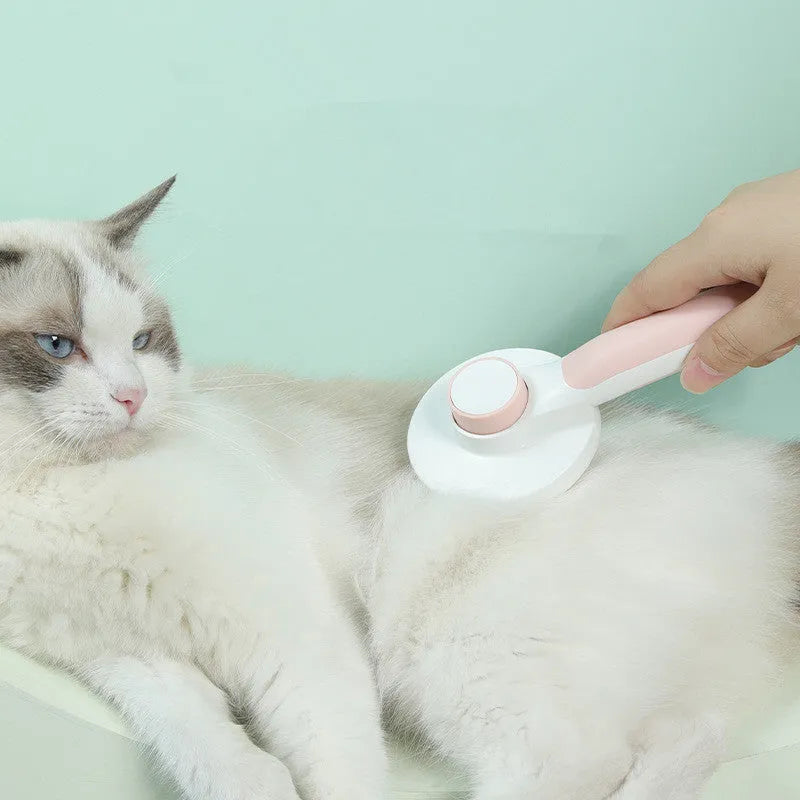 Round handle pet pass-through comb with stainless steel needles and self-cleaning button in pink colour