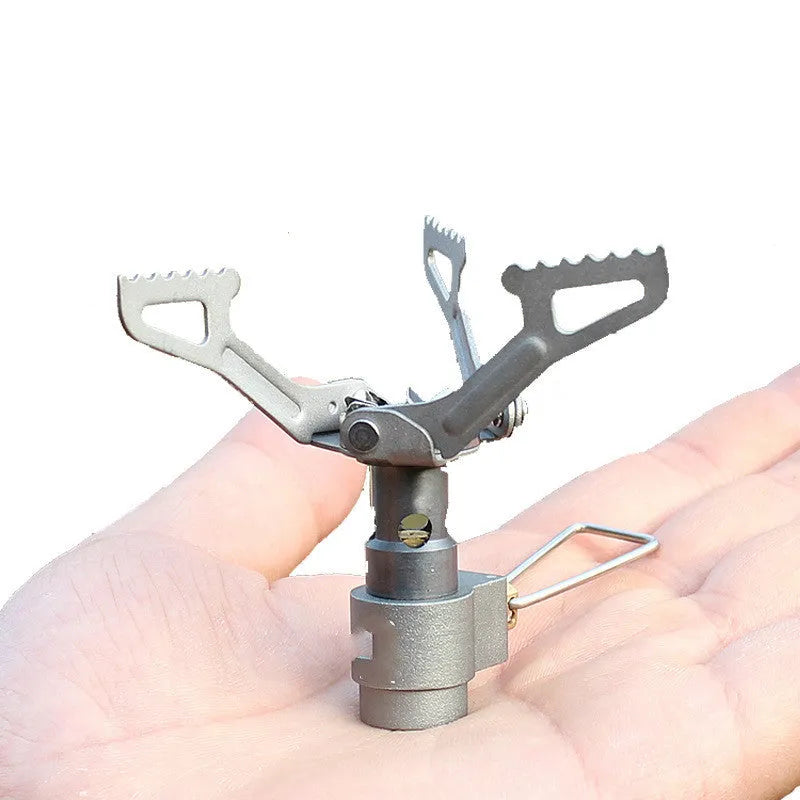 Compact portable gas camping stove with one-piece cast iron burner on a green background.