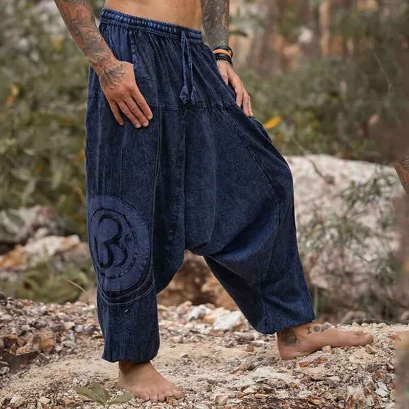 Dark green men's trousers with ethnic pattern design showing ankle-tied detail and mid-waist fit