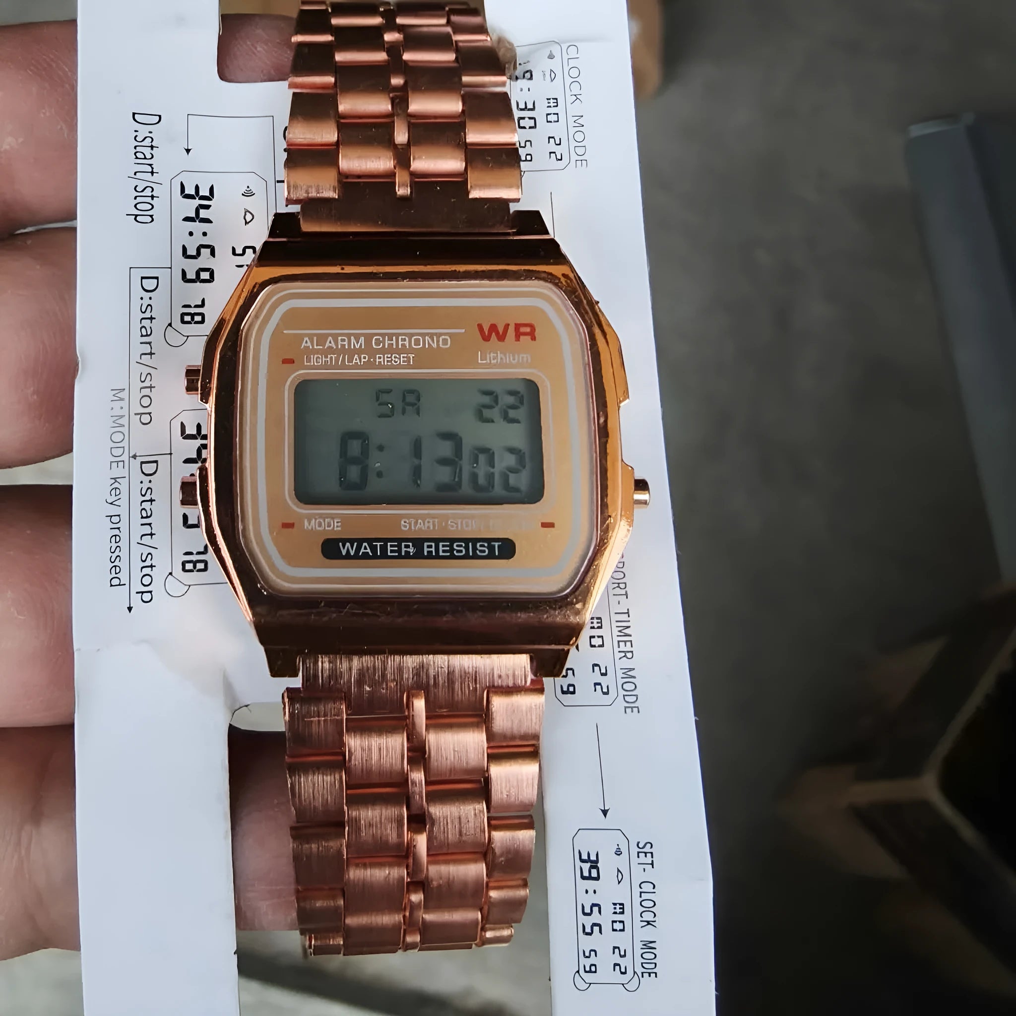 Rose gold analogue watch with round stainless steel case, luminous hands, and date display on a white background