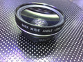 0.45X wide-angle mobile phone camera lens in silver finish attached to smartphone