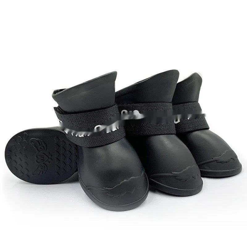 A set of four colourful rubber rain shoes for dogs, showing soft soles and bright pink, blue, orange, and red colours.