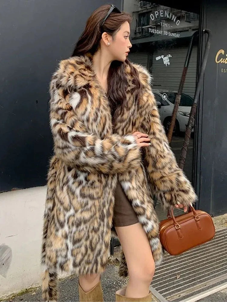 A person wearing a grey faux fur coat with a large fur collar and front pockets, in a street-fashion style.