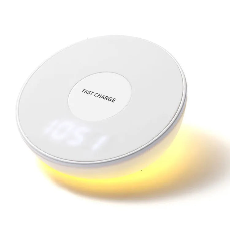 White wireless charging pad with digital clock display and night light, shown on a wooden surface.