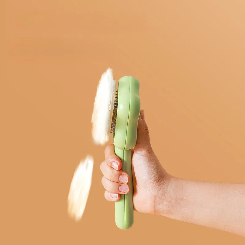 Green self-cleaning stainless steel magic wand cat comb on a white background.