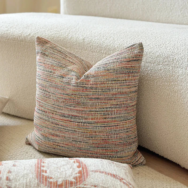 American-style jacquard paisley pattern sofa cushion cover in an amber colour on a grey sofa.