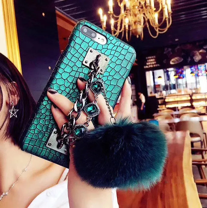 Red iPhone case with fox fur ball decoration and rhinestone studded design
