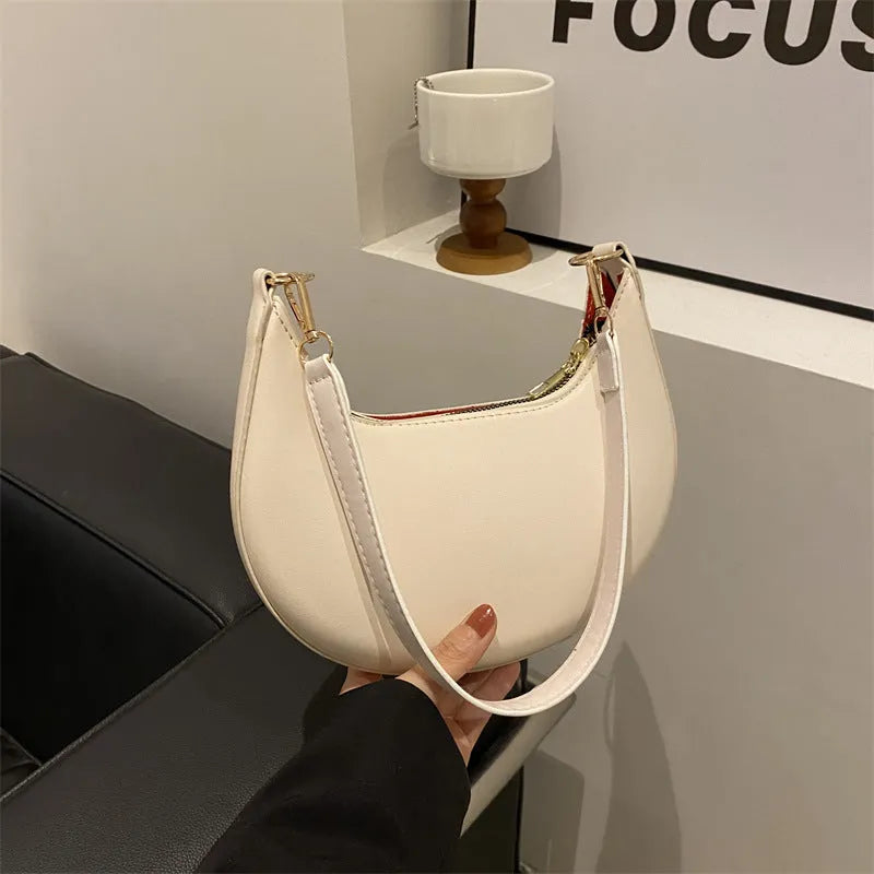 Round black women's one-shoulder underarm bag with sewing line details and a single strap.