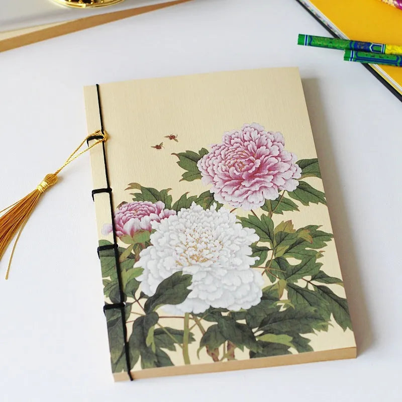 Antique wire-bound notebook with historical artwork cover and decorative tassels
