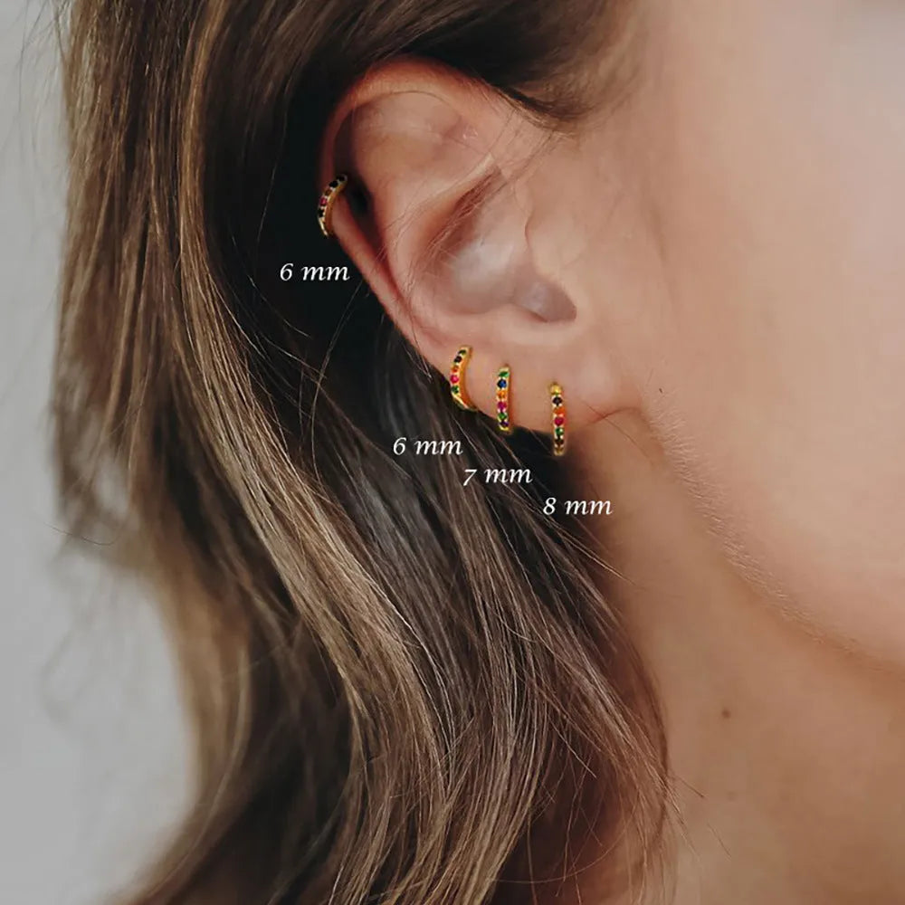 A pair of round geometric circle zircon stud earrings on a plain background, showing gold, rose gold, and silver colour options.