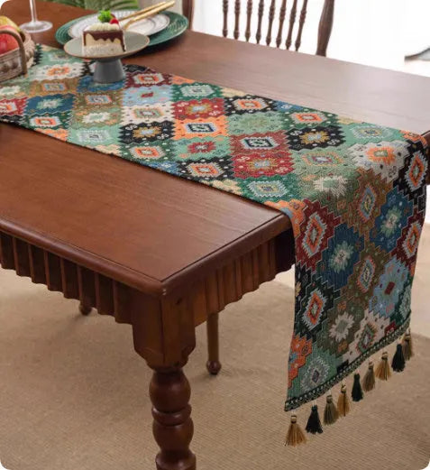 Country European retro style table flag with handwoven tassels in blue ginkgo leaf pattern lying on a wooden table.