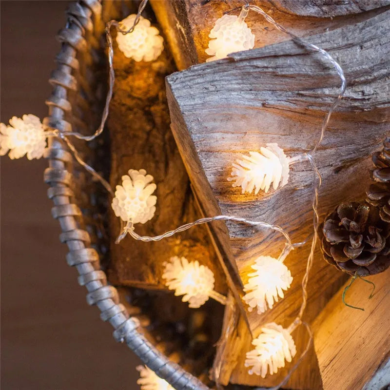 Warm white LED pine cone fairy lights on a string, battery-powered for indoor and outdoor decorative use.