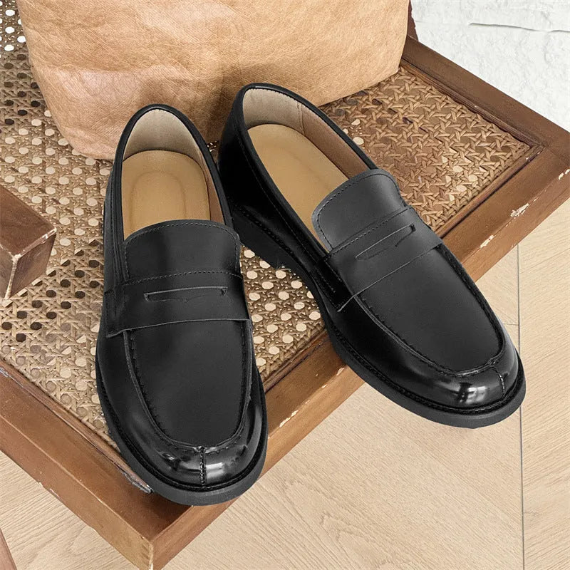 Men's black slip-on derby shoes with rubber sole showing height increasing feature