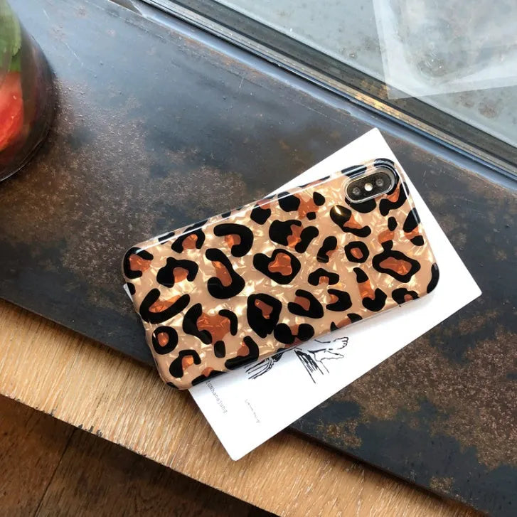 Colourful leopard print silicone TPU phone case for iPhone models on a table.