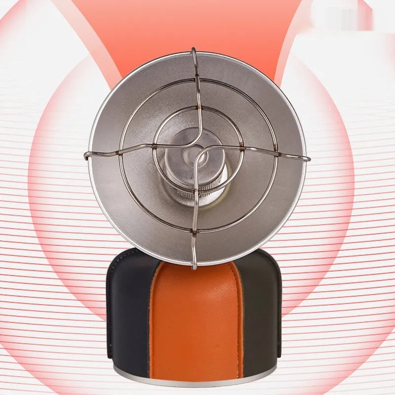 Black and orange portable camping stove with automatic ignition on a rocky outdoor surface.
