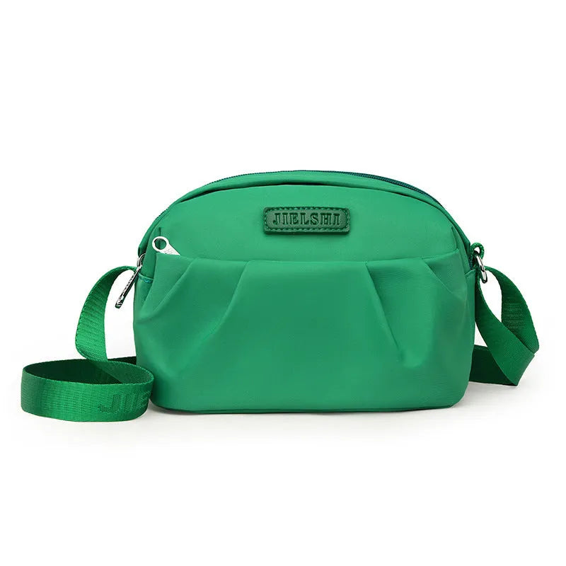 Pleated Oxford cloth horizontal messenger bag in cangling green, showing cross-body strap and external pocket.