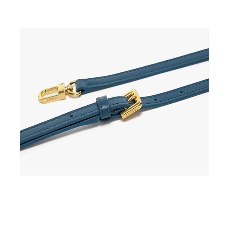 A women's leather wing-shaped tote bag with a metal latch, shown in blue on a cross-body strap.