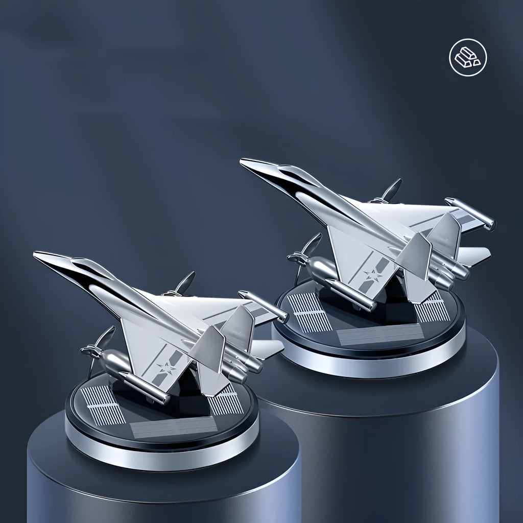 Silver solar-powered rotating fighter aircraft perfume ornament on a desk with essential oil bottle.