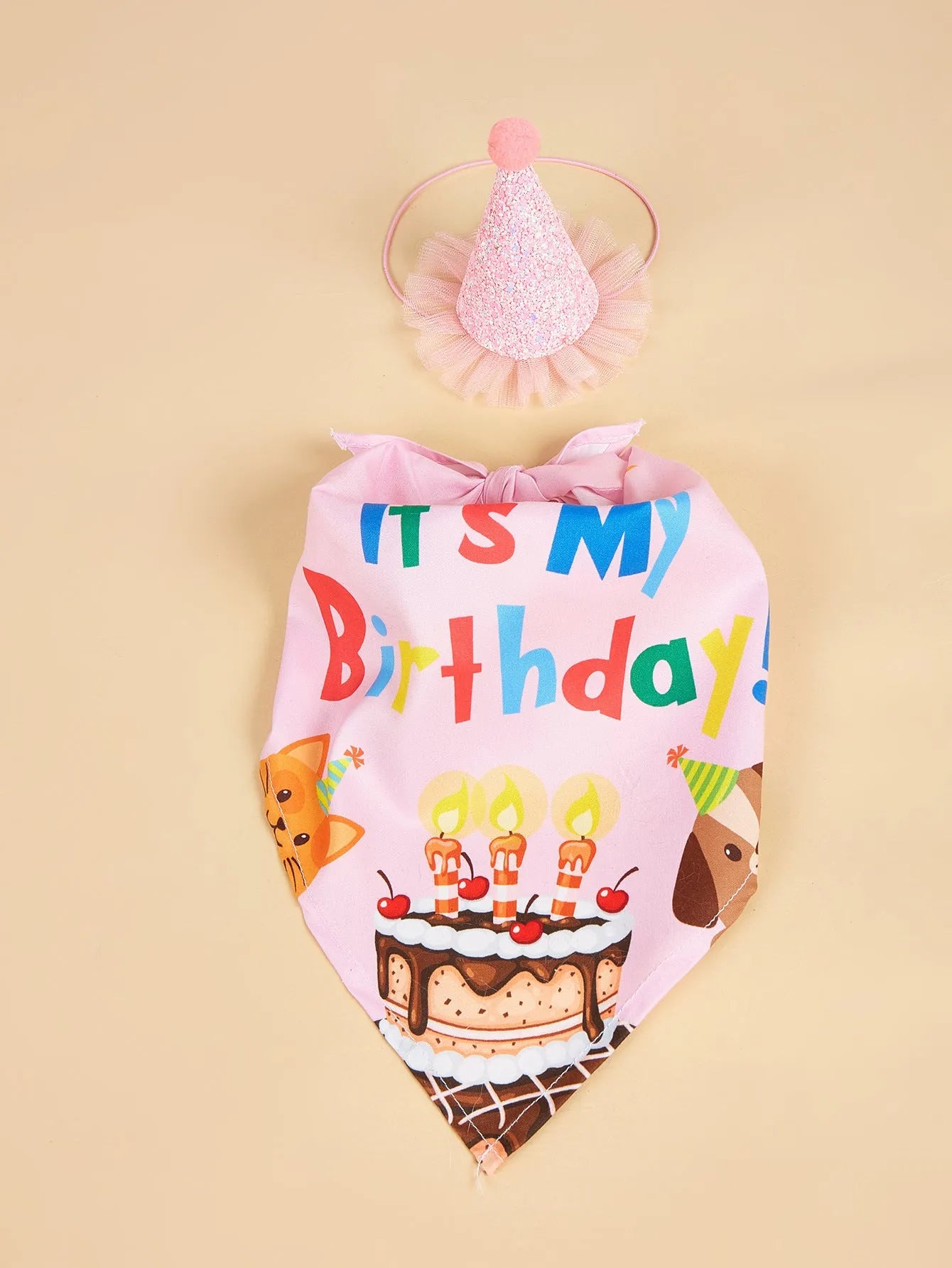 Printed polyester dog birthday hat and drool towel set in cartoon style with blue and pink colour options.