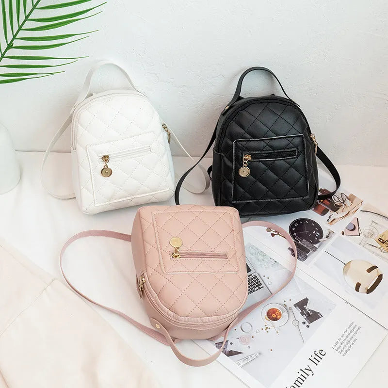 A white hard-shell girls backpack with embroidery, showing its square shape and soft top handle.