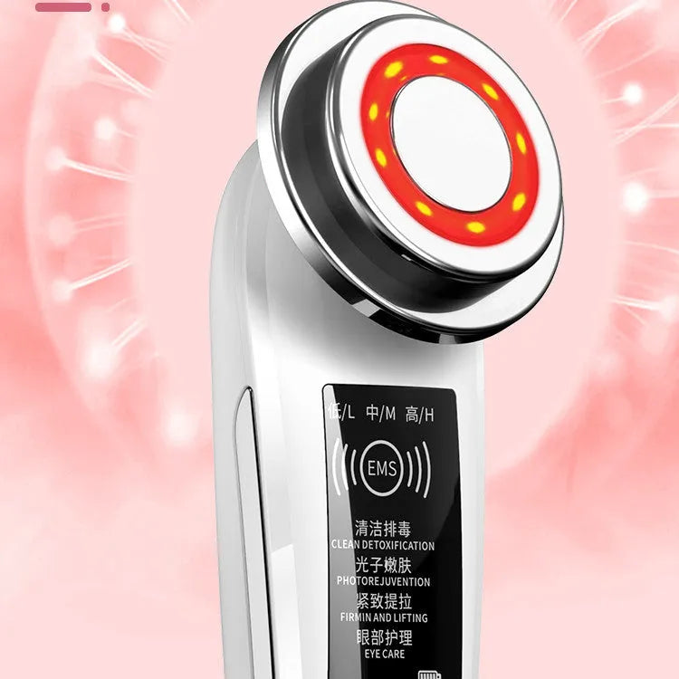 Pink and white rechargeable facial massager with red and blue light therapy functions on a clean surface
