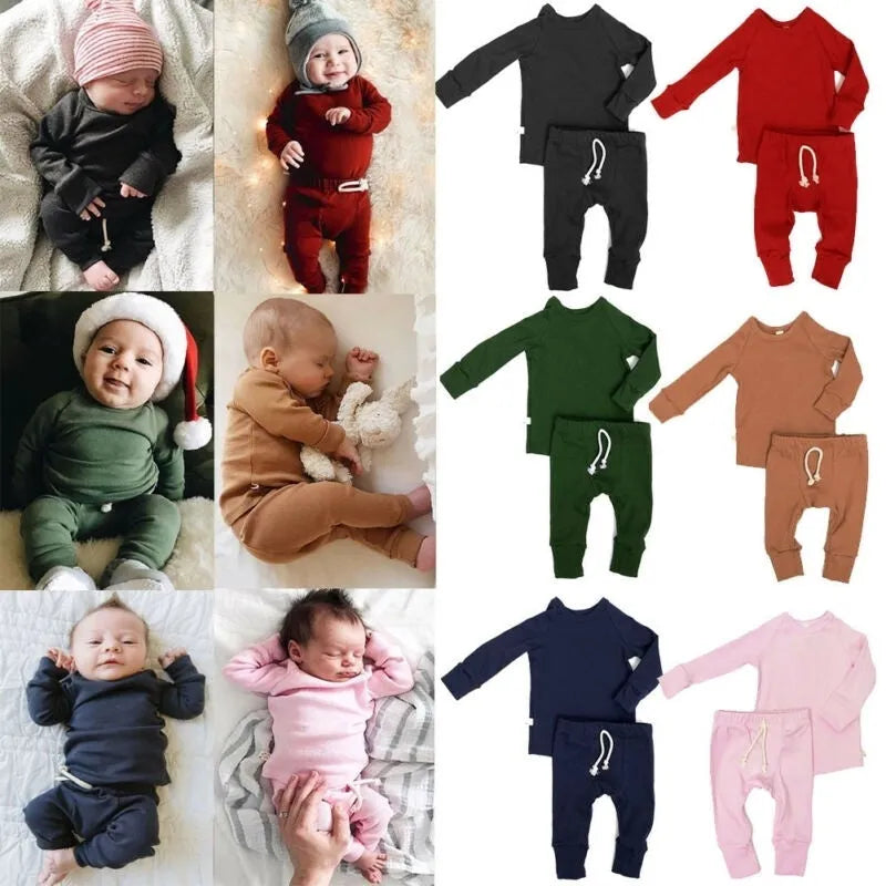 A baby wearing a blue cotton romper tracksuit set with a cartoon pattern, showing the one-piece design.