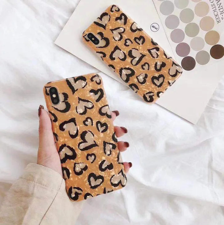 Colourful leopard print silicone TPU phone case for iPhone models on a table.