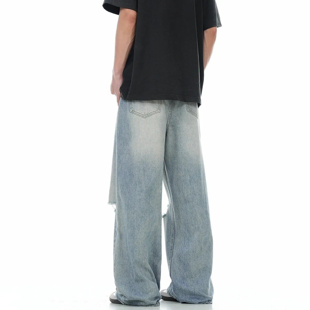 Men's blue straight-leg ripped jeans on a white background showing retro detailing and zip fly